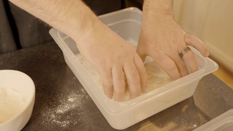 Placing dough balls in a floured proofing container