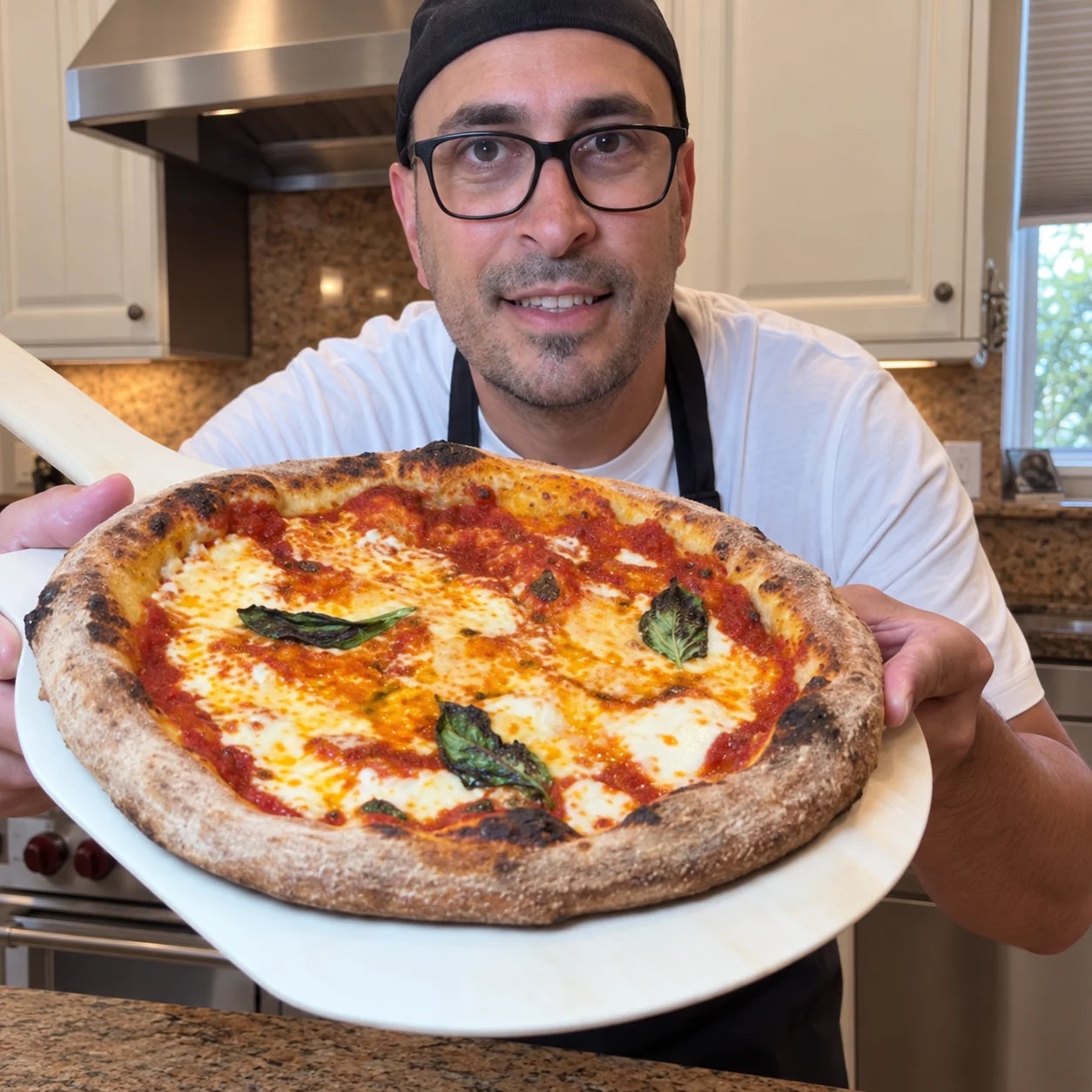 Poco Bero creator holding a freshly baked pizza toward the camera